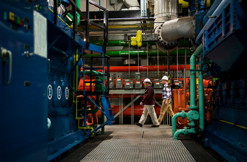 Steven Rose (left), the Cheyenne Mountain Air Force Station deputy director, and the safety chief walk through the Cheyenne Mountain Complex’s generator room on their way to the facility’s underground reservoirs. (U.S. Air Force photo/Staff Sgt. Andrew Lee)